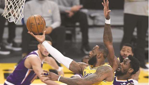 LeBron James of the Los Angeles Lakers scores past Deandre Ayton of the Phoenix Suns during a 114-104 Suns win at Staples Center in Los Angeles, California. (AFP)
