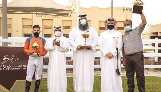 Qatar Racing and Equestrian Club Racing manager Abdulla Rashid al-Kubaisi with the winners of the Loyalty Cup after Burano Boy won the 2,100m feature at Al Uqda Equestrian Complex on Thursday. PICTURES: Juhaim