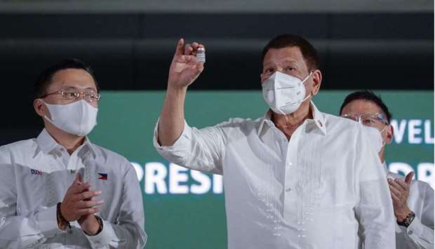 Philippine President Rodrigo Duterte holding a vial of the AstraZeneca Covid-19 vaccine during a ceremony at a military airbase in Manila