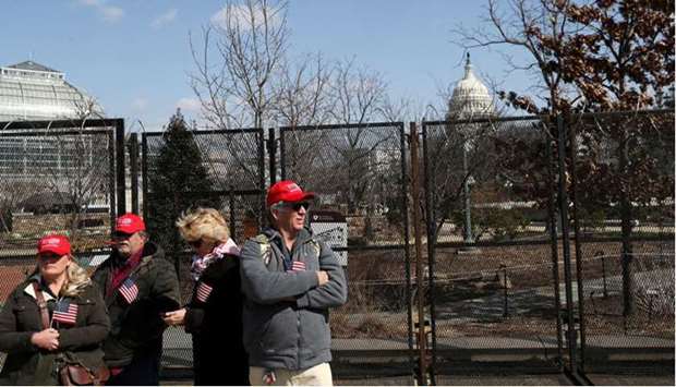 Trump supporters Karyn Carson (left), John Carson, Lois Houser and Matthew Giannini (right), stand yesterday near the security perimeter outside of the US Capitol Building, hoping to see evidence of the inauguration of the former president.