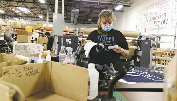 An employee reviews paperwork at the Gifts For You company warehouse in Woodridge, Illinois. US economy added 379,000 jobs in February, slowly closing pre-pandemic gap.