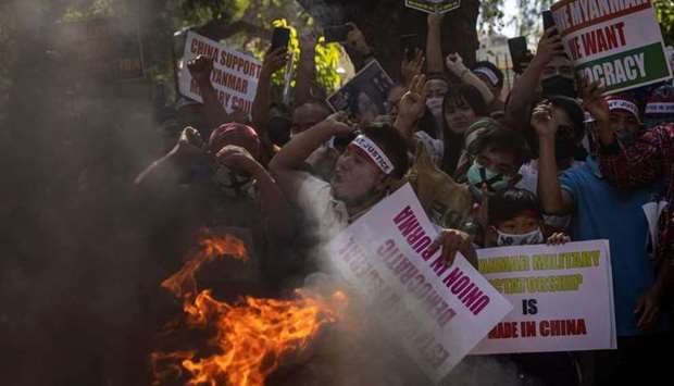 Myanmar citizens living in India shout slogans as they burn a poster of Myanmar's army chief Senior General Min Aung Hlaing during a protest, organised by Chin Refugee Committee, against the military coup in Myanmar, in New Delhi, India, March 3