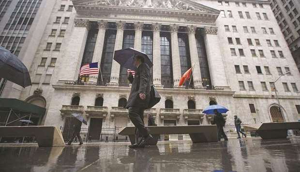 Pedestrians walk past the New York Stock Exchange. As US technology shares stumble, investors are debating whether the decline is an opportunity to scoop up bargains or a sign of more pain to come for stocks that have led markets higher for years.