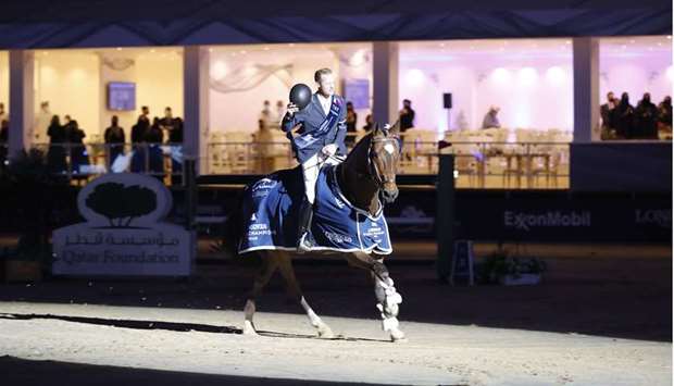 Belgian rider Niels Bruynseels astride bay gelding Delux van T & L celebrates after winning the Grand Prix of Doha at the Longines Global Champions Tour at the Longines Arena at AL Shaqab