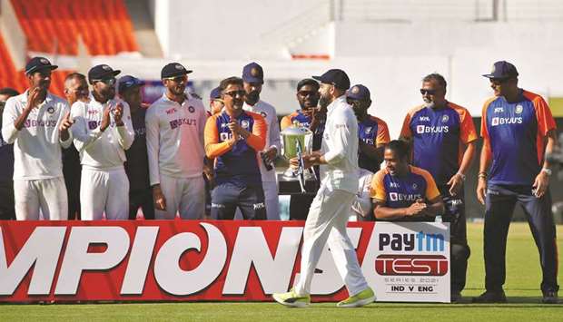 Indiau2019s captain Virat Kohli carries the series winnersu2019 trophy to celebrate with his teammates after they won the fourth Test against England at Narendra Modi Stadium in Ahmedabad, India, yesterday. (Reuters)