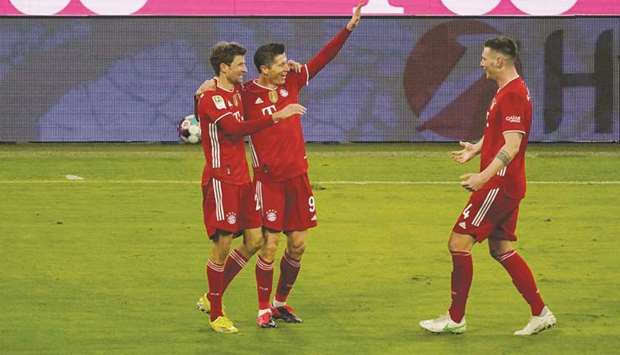 Bayern Munichu2019s Polish forward Robert Lewandowski (C) celebrates with teammates after scoring during their 4-2 win over Borussia Dortmund in Munich yesterday.