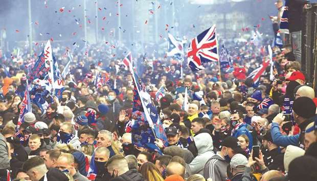 Rangers fans celebrate outside Ibrox Stadium, home of Rangers Football Club, in Glasgow yesterday after their first Scottish Premiership title for 10 years was confirmed. At right, coach Frank Lampard.