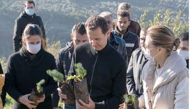 Syria's President Bashar al-Assad and his wife Asma, plant trees in city of Draykish, near Tartous, Syria on December 30, 2020.  SANA/Handout via REUTERS