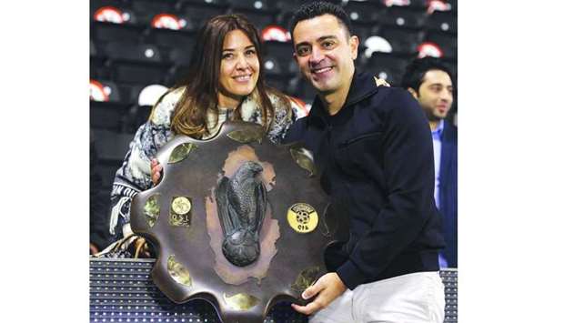 Al Sadd coach Xavi Hernandez celebrates with his wife Nuria Cunillera and Falcon Shield after leading the club to QNB Stars League title on Sunday.
