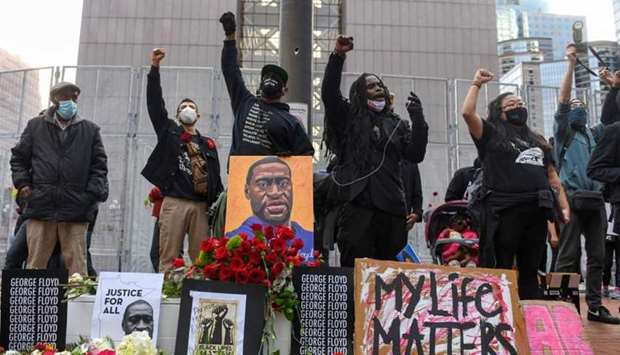Protesters raise their fists and chant after the ,I Can't Breathe, Silent March for Justice a day before jury selection is scheduled to begin for the trial of Derek Chauvin, the former Minneapolis policeman accused of killing George Floyd, in Minneapolis, Minnesota