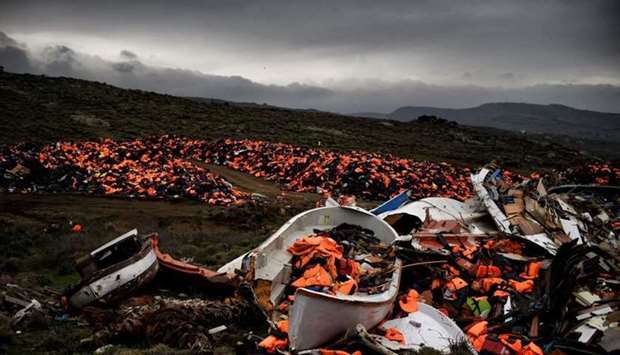 In this file photo taken on February 19, 2016, wrecked boats and thousands of life jackets used by refugees and migrants during their journey across the Aegean sea lie in a dump in Mithimna