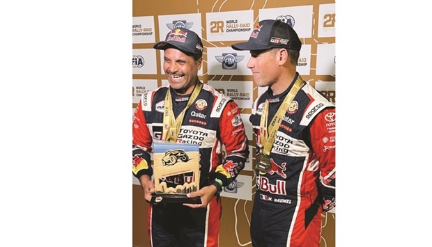 Qataru2019s Nasser Saleh al-Attiyah is all smiles as he poses with French co-driver Mathieu Baumel after winning the fourth successive stage at the Abu Dhabi Desert Challenge on Thursday.