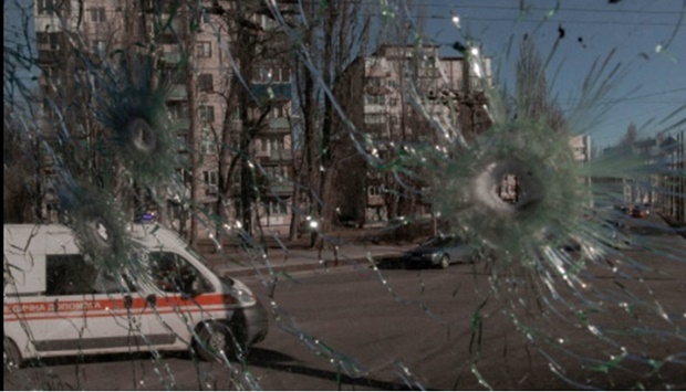 An ambulance is seen through the damaged window of a vehicle hit by bullets, as Russia's invasion of Ukraine continues, in Kyiv, Ukraine February 28, 2022.