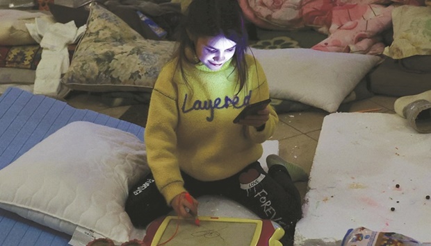 A girl plays inside a makeshift camp, inside the VIP hall at the train station in Lviv, Ukraine, for women and children who fled the ongoing Russian invasion before their transfer to Poland.