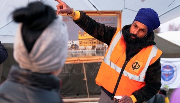 A man from the organization United Sikhs, which provides Indian food at a crossing on the Ukrainian-Polish border for people fleeing the Russian invasion of Ukraine, gestures as he speaks to a person, at the border checkpoint in Medyka, Poland. REUTERS