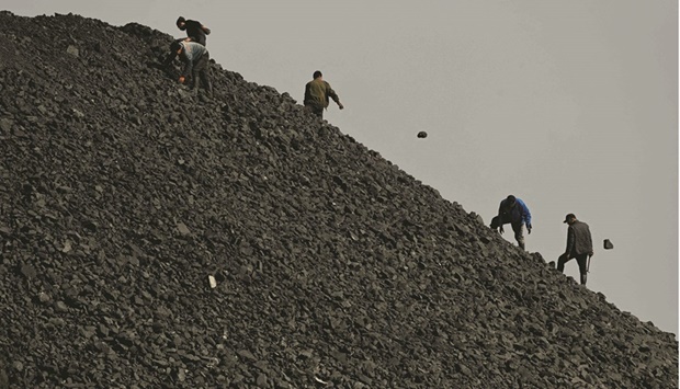 Workers sort coal near a coal mine in Datong, Chinau2019s northern Shanxi province. Faced with energy turmoil, China is returning to its old habit of coal, no matter what damage it does to climate momentum.