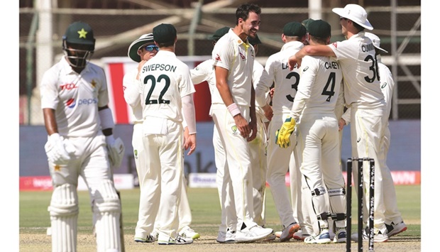 Australiau2019s Mitchell Starc (centre) celebrates with teammates after the dismissal of Pakistanu2019s Shaheen Shah Afridi during the third day of the second Test at the National Cricket Stadium in Karachi yesterday. (AFP)