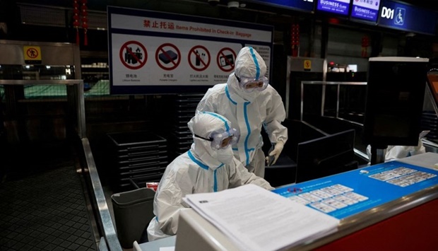 Airline staff wear personal protective equipment (PPE) to protect against coronavirus disease as they work at Beijing Capital International airport in Beijing, China March 13, 2022.