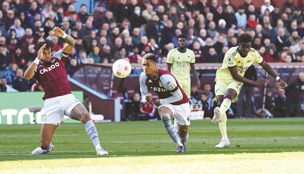 Arsenalu2019s Bukayo Saka (right) scores during the Premier League match against Aston Villa in Birmingham yesterday. (Reuters)