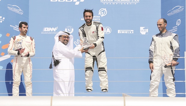 Qatar Motor & Motorcycle Federation and Lusail Circuit Sports Club President Abdulrahman al-Mannai presents a trophy to Qatar Touring Car Championship race winner Abdulla al-Khelaifi at the Losail International Circuit yesterday.