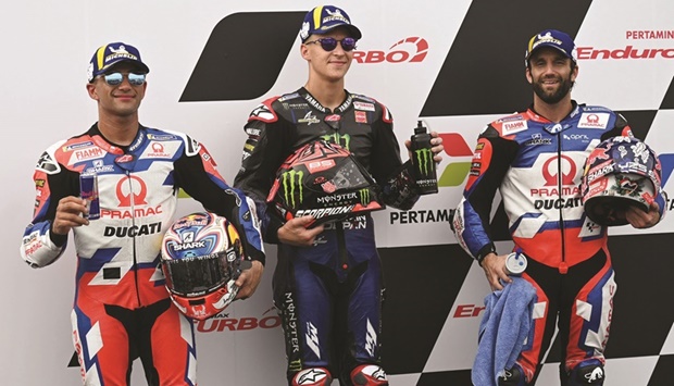 First-placed Monster Energy Yamaha MotoGPu2019s French rider Fabio Quartararo (centre), second-placed Pramac Racingu2019s Spanish rider Jorge Martin (left) and third-placed Pramac Racingu2019s French rider Johann Zarco pose after the qualifying session of the Indonesian Grand Prix at the Mandalika International Circuit in Central Lombok, Indonesia, yesterday. (AFP)