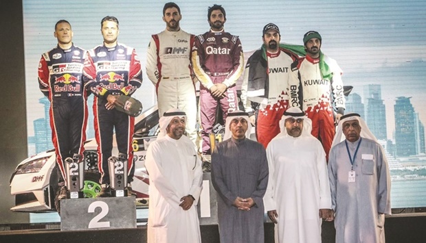 Podium winners of the Kuwait International Rally pose with the officials during the presentation ceremony yesterday.