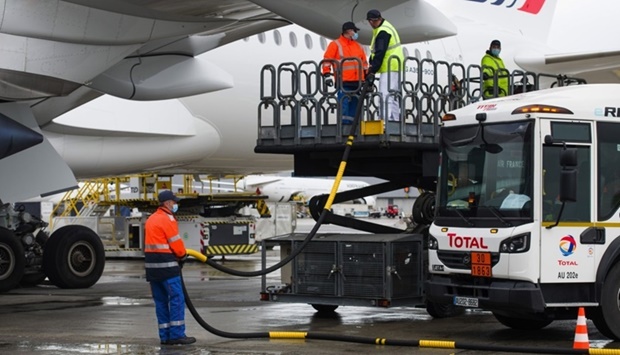 Workers connect a Total tanker truck to an Airbus A350 passenger plane, operated by Air France-KLM, during fuelling with sustainable aviation fuel at Charles de Gaulle airport in Roissy, France (file). The development and deployment of SAF is the biggest area of opportunity for long-term reductions in aviation emissions, according to IATA.