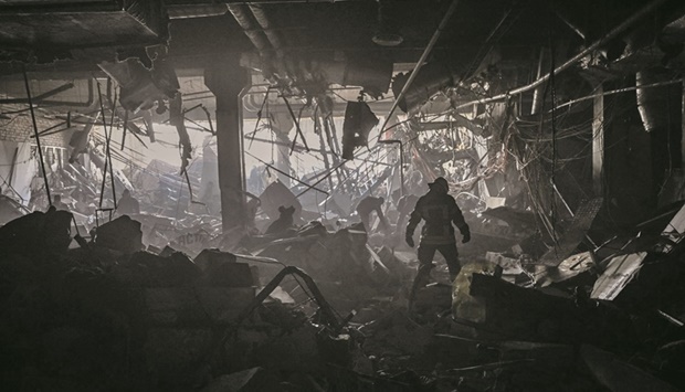 A Ukranian serviceman walks between debris inside the Retroville shopping mall after a Russian attack on the northwest of the capital Kyiv yesterday. The 10-storey building was hit by a powerful blast that pulverised vehicles in its car park and left a crater several metres wide. (AFP)