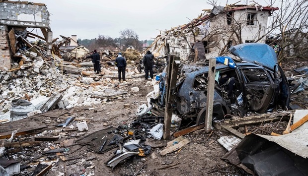 Local residents stand in front of residential buildings destroyed by shelling, as Russia's invasion of Ukraine continues, in Zhytomyr, Ukraine Wednesday