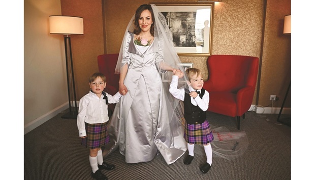 Stella Moris, partner of WikiLeaks founder Julian Assange, poses with their sons in a hotel room in London before driving to Belmarsh Prison where she married Assange yesterday. (AFP)