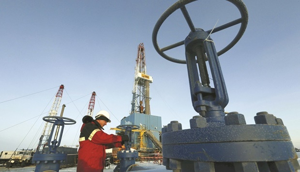 A worker checks a valve of an oil pipe at the Lukoil company owned Imilorskoye oil field outside the West Siberian city of Kogalym, Russia (file).