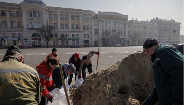 People fill sandbags used to protect monuments against damage from shelling as Russia's attack on Ukraine continues, in Kharkiv, Ukraine. REUTERS