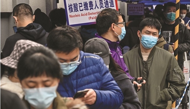 People queue to be tested as a measure against the Covid-19 coronavirus at Shanghai Jingu2019an Central Hospital in Shanghai. China  reported 5,600 new Covid-19 cases on Saturday, the most daily infections in more than two years.