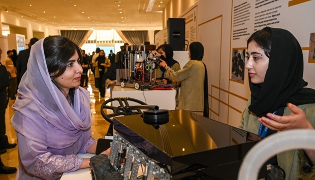 Malala Yousafzai talking to a member of the Afghan Girls Robotics Team at the Doha Forum