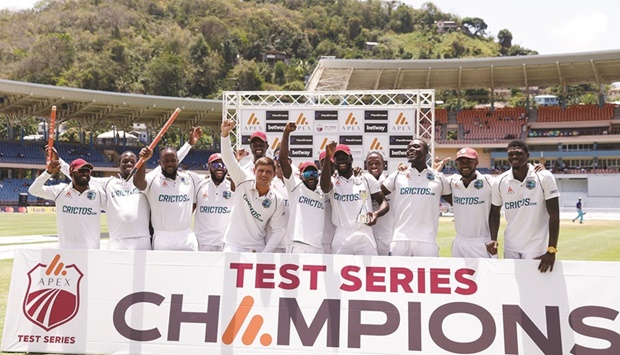 West Indies players celebrate with The Richards-Botham Trophy after winning the third Test against England at the National Cricket Stadium at St Georgeu2019s, Grenada, yesterday. (Reuters)