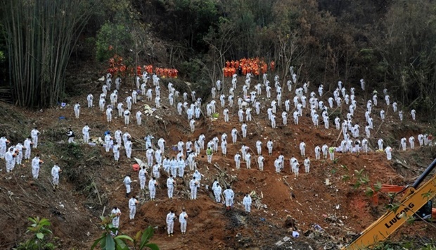 Rescue workers stand in a silent tribute at the site to mourn the victims of a China Eastern Airlines plane, on March 27. cnsphoto via REUTERS