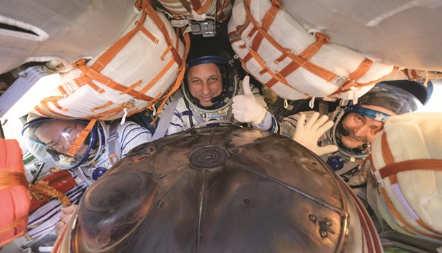 Russian cosmonauts Pyotr Dubrov (R) and Anton Shkaplerov (C) and Nasa astronaut Mark Vande Hei (L) inside the Soyuz MS-19 space capsule shortly after the landing in a remote area in Kazakhstan yesterday. (AFP)