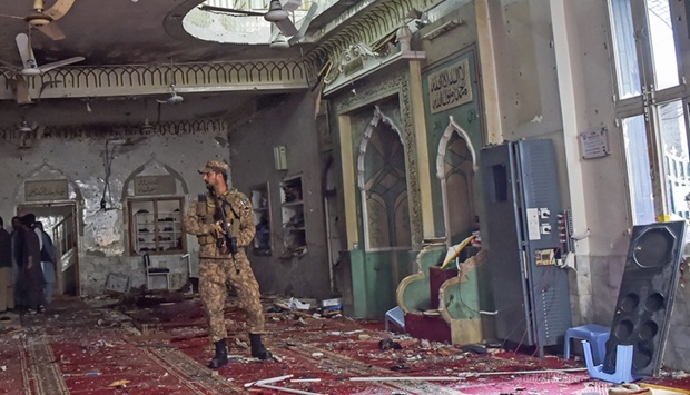 A soldier stands guard inside a mosque after a bomb blast in Peshawar on March 4, 2022.