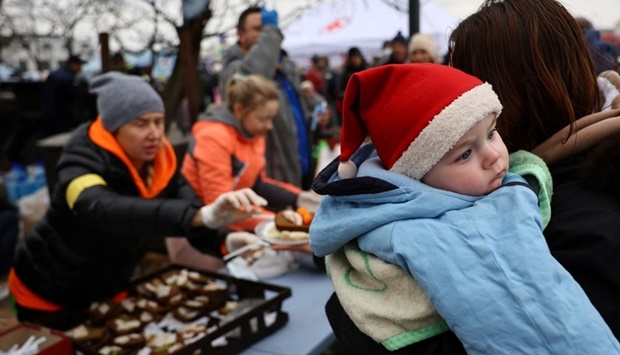 Refugees share a meal as they wait for transfer after fleeing the ongoing Russian invasion at the main train station in Lviv, Ukraine. REUTERS/Kai Pfaffenbach