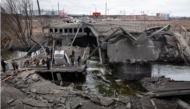 Evacuees fleeing Ukraine-Russia conflict cross a destroyed bridge in the town of Irpin in the Kyiv region, Ukraine. REUTERS