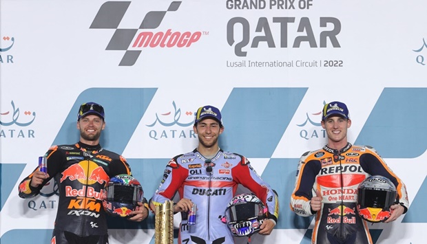 Gresini Racing MotoGP's Enea Bastianini celebrates on the podium with the trophy after winning the race with second place Red Bull KTM Factory Racing's Brad Binder and third place Repsol Honda Team's Pol Espargaro.