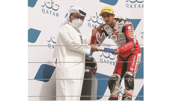 Qatari rider Hamad al-Sahouti receives his trophy from Qatar Motor and Motorcycle Federation and Lusail Circuits Sports Club president Abdulrahman al-Mannai at the Losail International Circuit on Sunday.