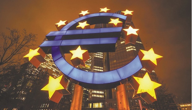 The euro sculpture illuminated outside the Eurotower, the former headquarters of the European Central Bank in Frankfurt. ECB officials on alert for any sign record inflation might ignite wage pressures are now wondering if they may need to keep waiting.
