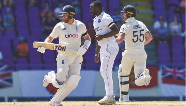 Jonny Bairstow (left) and Ben Stokes of England get runs off Kemar Roach (centre) of West Indies during the first day of the first Test at Vivian Richards Cricket Stadium in North Sound, Antigua and Barbuda, yesterday. (AFP)