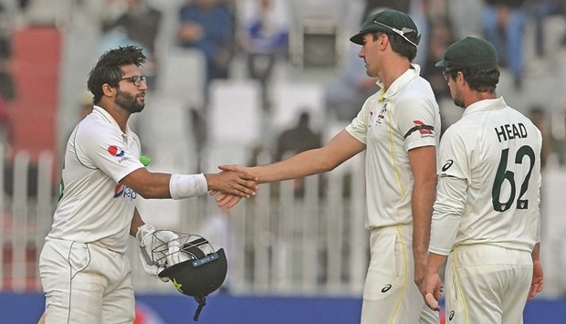 Pakistanu2019s Imam-ul-Haq (left) shakes hand with Australiau2019s captain Pat Cummins after a draw in the first Test at the Pindi Cricket Stadium in Rawalpindi yesterday. (AFP)