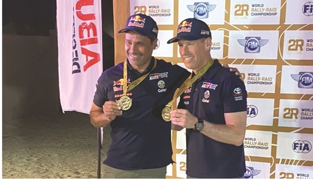 Qataru2019s Nasser al-Attiyah and his French co-driver Mathieu Baumel pose with their medals after winning the third stage at the Abu Dhabi Desert Challenge on Wednesday.