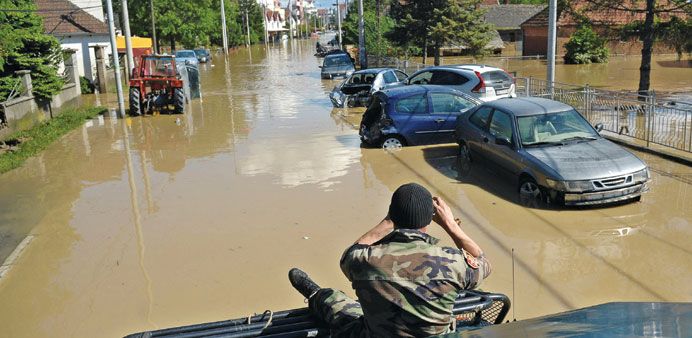 A Serbian rescue worker takes photos of damaged vehicles in the flooded town of Obrenovac, 40km west of Belgrade.