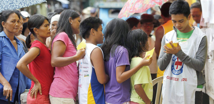 Filipino typhoon victims waiting in line  to receive relief aid in the eastern Samar village of Balangkaya yesterday.