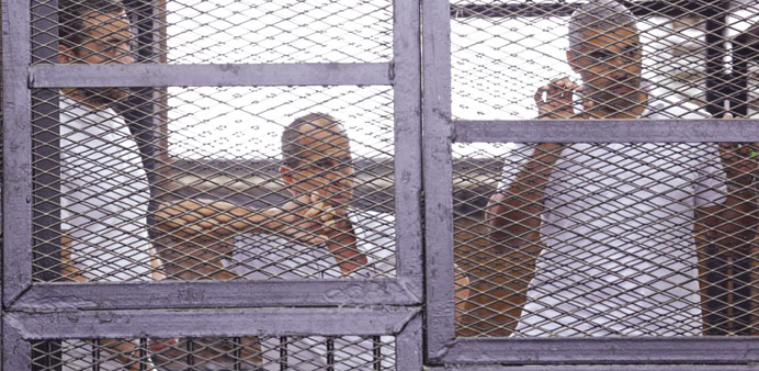 Al Jazeera journalists  Baher Mohamed, Peter Greste and Mohamed Fahmy stand behind bars in a court in Cairo in this June 1 file photo.