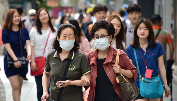 Women wearing face masks walk in a shopping district in Seoul. AFP